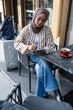 © Jovo Jovanovic/Stocksy - Woman in hijab works on tablet at outdoor cafe.