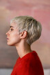 © OchreOchre/Stocksy - Side Profile Of A Woman With Short Platinum Hair In Red Sweater