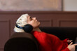 © OchreOchre/Stocksy - Blonde Woman Relaxing On Couch With Headphones Listening To Music