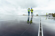 © Artcore Studio/Stocksy - Engineers inspecting solar panels on rooftop sustainability project