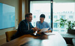 © Artcore Studio/Stocksy - Business colleagues discussing documents during office meeting