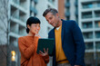 © Artcore Studio/Stocksy - Business colleagues reviewing digital tablet content outdoors