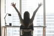 © fizkes - Workday success joy. Back view happy millennial businesswoman employee student enjoy freedom after finishing task at modern office desk stretch hands up relieve stress tension celebrate work victory