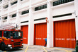 © Ayuna Production/Stocksy - Red fire truck outside modern fire station
