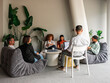 © Aleksandra Jankovic/Stocksy - Casual Office Lounge Meeting With Diverse Team Laughing, Working