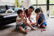 © NZstockphoto - Two children and a woman enjoy building with colourful blocks in a bright room