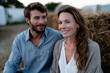 © Milos - A cheerful couple relaxes together on a farm, enjoying a moment of happiness, demonstrating love and connection amid the serene backdrop of nature and countryside life.