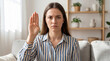 © David Zarzosa - Woman raising hand as a signal for help and female protection at home.