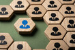 © Ajay - Standout leader blue businessman figure among wooden hexagon team on green felt board, Unique employee individual hexagonal crowd concept.