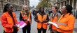 © Fana Art - Volunteers Spreading Awareness in London, Bright Orange Vests, Historic Buildings Backdrop