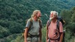 © mila103 - Two men with backpacks smile and talk to each other during a hike in the mountains. They are enjoying their time outside surrounded by trees on a sunny day.