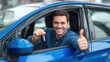 © LimeSky - Joyful young man with a thumbs up holding keys in his new blue car outside a dealership Car ownership idea