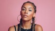 © Glitchmint - Beautiful woman with braids and hoop earrings poses against a pink backdrop