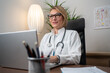 © Nenad - Female doctor with laptop working at the office desk.