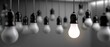 © pvl0707 - One bright light bulb stands out among many dark bulbs in a black space, symbolizing a unique idea and creativity in design and lighting
