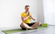 © Ievgen Skrypko - Sporty Young Man Practicing A Yoga Routine While Sitting In A Lotus Pose On A Mat