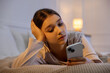© New Africa - Teenage girl using smartphone on bed at home