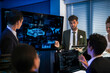 © ultramansk - Automotive executives discussing electric car market strategy. Business leadership team analyzing vehicle sales data and future design trends in modern night office.