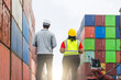 © JU.STOCKER - Logistics Workers Looking at Stacked Cargo Containers at Commercial Port Terminal, Multi-Ethnic Warehouse Staff Standing in Front of Colorful Shipping Containers for Global Export