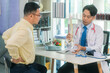 © ArLawKa - An Asian male doctor is explaining spinal X-ray images to an elderly patient, holding a spinal model and explaining the cause of the patient's pain.