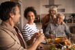 © Jelena - Multi-generational family enjoying a celebratory meal together
