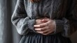 © Oleh - Woman holding her stomach with both hands, experiencing discomfort and pain from abdominal cramps, potentially caused by indigestion, period pain, or a general illness