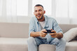 © SHOTPRIME STUDIO - Happy man playing video games at home, enjoying his digital detox while embracing authentic imperfection and soft masculinity in a cozy atmosphere.