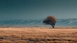 © Mr. Designer - Resilient solitary tree stands against the powerful forces of nature in a vast, wind-swept golden meadow, with majestic snow-dusted mountains under a dramatic teal sky, showcasing serene yet raw wilde