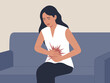 © Mandeep - Stressed young woman suffering from stomach ache abdominal pain sitting on sofa at home upset girl having menstrual period cramps indigestion or food poisoning health problem healthcare and medical il