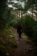 © JaviJfotografo - Woman walking on a mountain trail at sunset during autumn on the Hermitages route in Tella Pyrenees Spain
