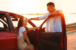© New Africa - Happy couple near car outdoors at sunset. Summer trip