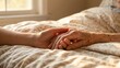 © Happy Hues - Close-up of young hand holding elderly hand providing support and comfort in hospice care