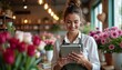 © AiGalaxy - Young beautiful woman florist using digital tablet in flower shop, smiling caucasian female entrepreneur with tablet for small business concept.