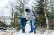 © Elena Medoks - Father caring for son during winter forest hike