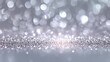 © Jam - A shimmering silver background features soft lighting and bokeh effects that create a visually interesting surface for designs and projects