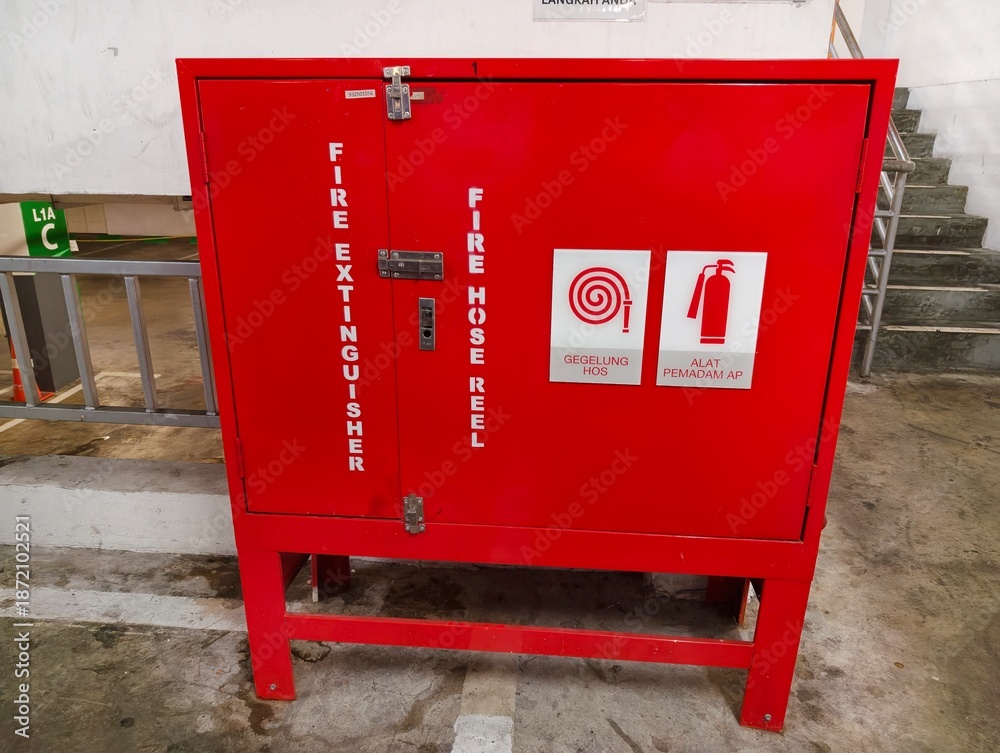 Fire safety cabinet with hose reel and extinguisher signage in ...