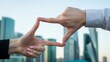 © dgpatel - Two hands create a perfect rectangular frame against a modern city skyline, symbolizing a focused vision, strategic planning, and capturing urban development opportunities.