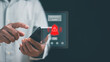 © krungchingpixs - Emergency alert concept. Hand using smartphone with warning notification and alert icon on screen. Crisis notification, emergency response, risk management, mobile technology, public safety system.