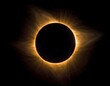 © Hasan - A stunning display of a total solar eclipse. The dark lunar disc is framed by a luminous, fiery corona, radiating outward against the black void