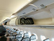 © fadfebrian - Carry on baggage on the overhead bin of the aircraft cabin