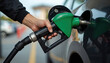 © miss irine - Person refueling car at gas station holds fuel pump nozzle. A hand inserts the fuel pump into the car fuel tank. Concept of car maintenance energy or transportation.