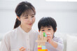 © kapinon - 積み木や知育をお母さんと一緒に成功するハイタッチする幼児　非認知能力を育むチャレンジや褒める母親のクローズアップ