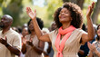 © SERHII - An African American woman with hands raised in worship during an outdoor church service. Spiritual person expressing faith and gratitude with her community