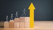 © Qaisar  - Four stick figures ascending wooden block staircase toward large upright yellow arrow symbolizing growth and success.