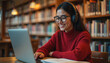 © Vadym - Young woman in glasses wearing headphones uses laptop. She smiles studying or attending online class at library. Distance education tech e learning concept. Female student looks happy.