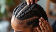 © Vadym - Pro hairdresser braids dark hair in neat cornrow patterns. Close-up shot shows scalp neat sections and detailed styling of hair. Artistic coiffure creation for woman.