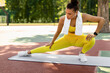 © Prostock-studio - Sport And Healthy Lifestyle Concept. Fit black woman doing side lunges, exercising outdoors on mat at basketball stadium. Portrait of confident lady training in wireless earbuds, full body length