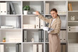 © Pixel-Shot - Businesswoman searching for document in office