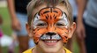 © logitech - Smiling Boy with Tiger Face Paint, Close-Up Portrait, Joyful Expression