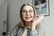 © shurkin_son - Closeup indoor image of intelligent smart aged woman therapist or psychologist gesticulating while explaining topic to followers or students looking online at camera sitting in cabinet or cozy office